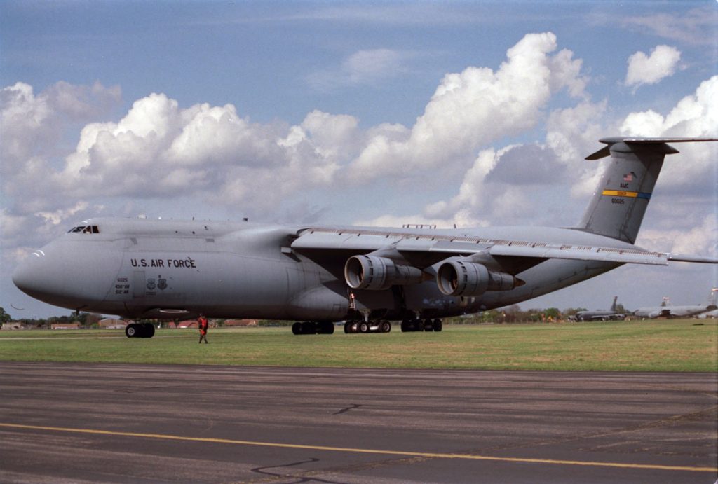 avião militar C-5M Super Galaxy carregando equipamentos pesados em base aérea