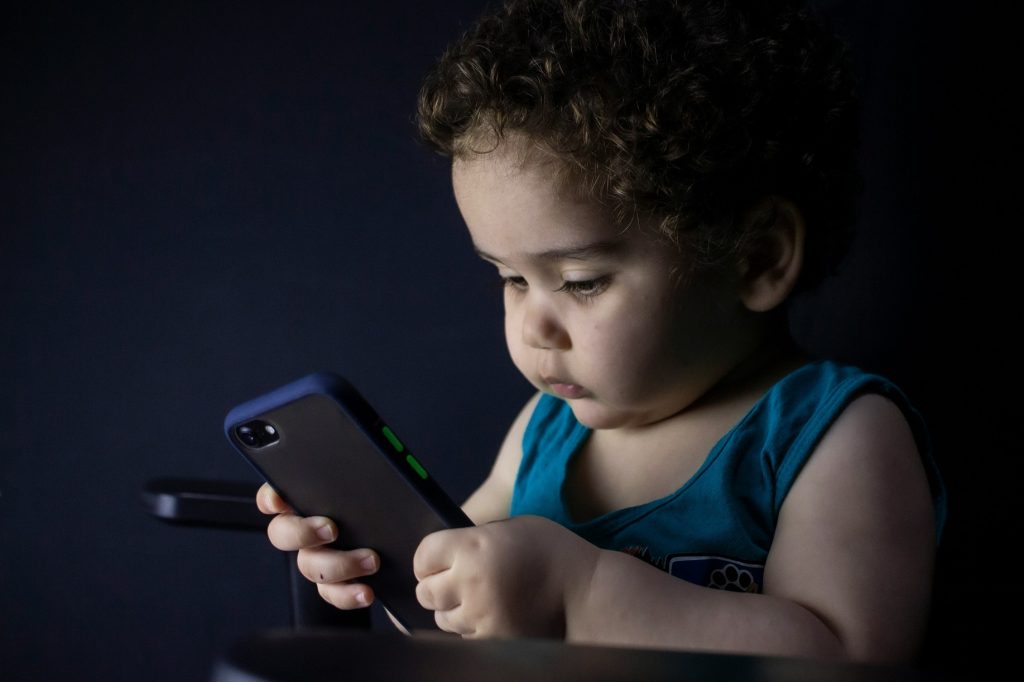 Criança usando smartphone com acesso à internet