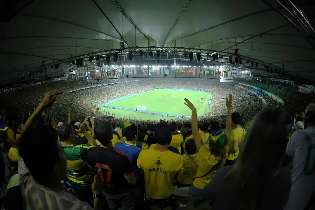 Interior do Estádio do Maracanã em dia de jogo com a torcida vibrando.