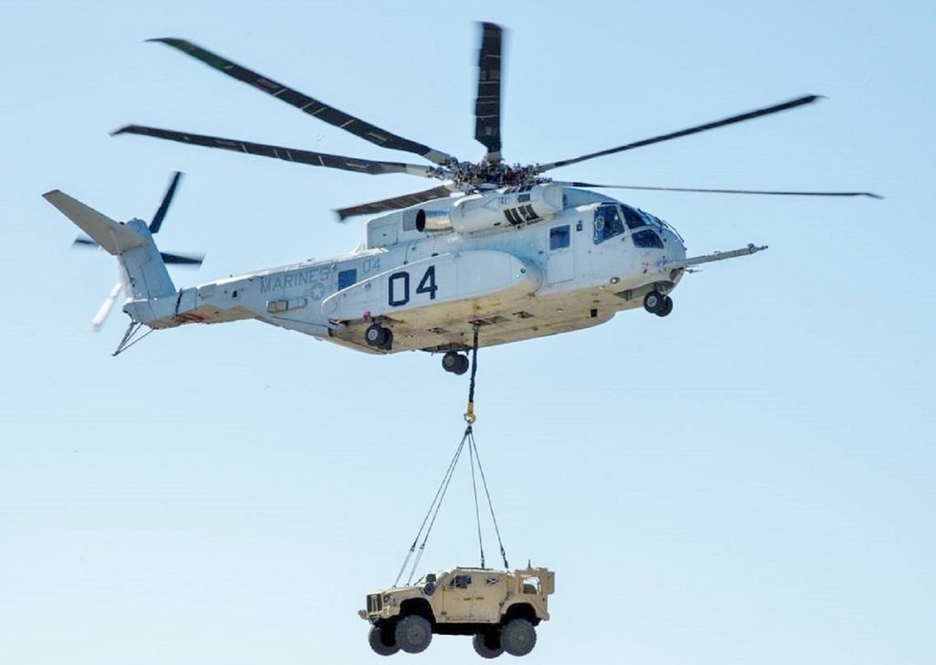 helicóptero militar CH-53K levantando carga pesada em missão logística