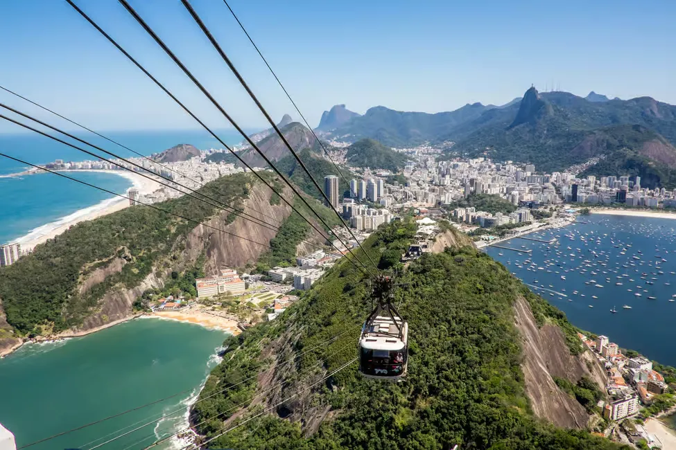Detalhe dos bondinhos vermelhos do Pão de Açúcar com a Baía de Guanabara ao fundo.