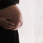 Mulher grávida olhando pensativamente — mudanças cerebrais na gravidez