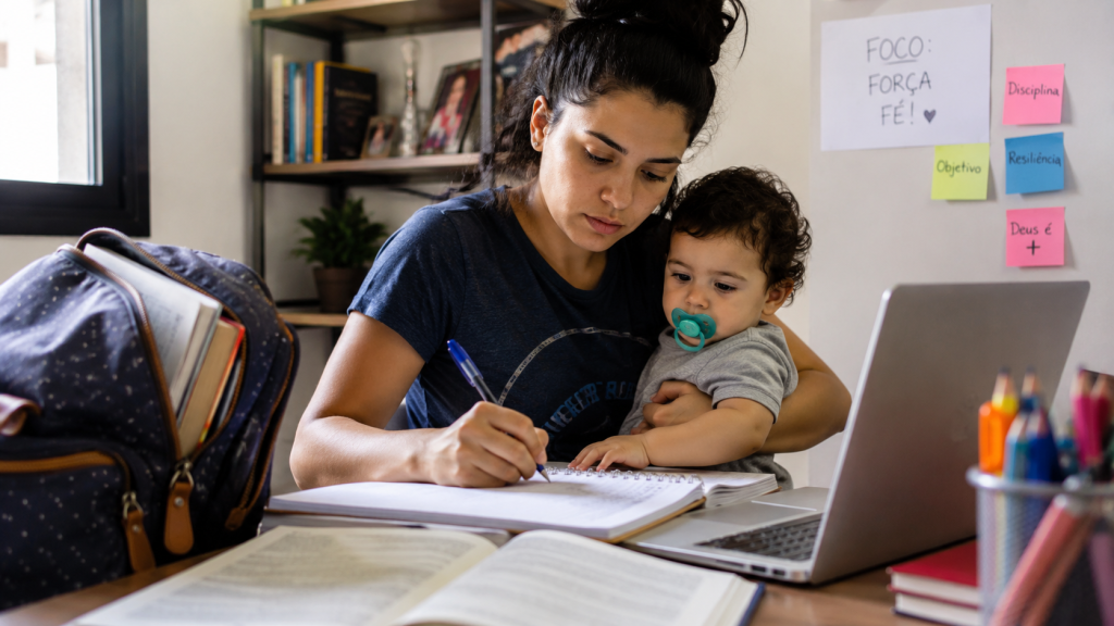 Mãe universitária estudando com o filho pequeno ao lado